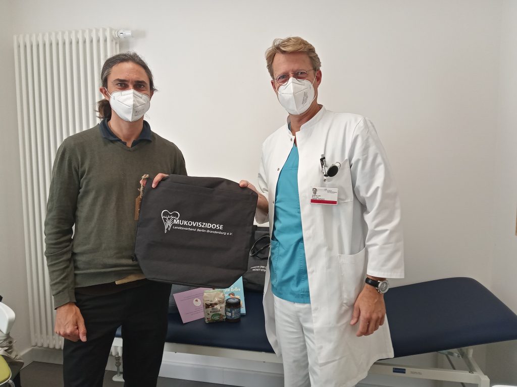 Eine Tasche wird von einem Mann an einen Arzt übergeben