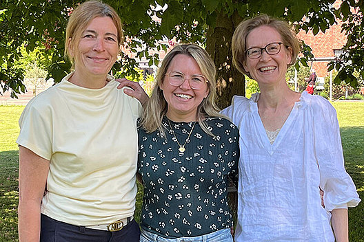 Drei Frauen stehen eng beieinander im Freien und lächeln in die Kamera, Vorstellung des neuen Vorstands des Mukoviszidose e. V.